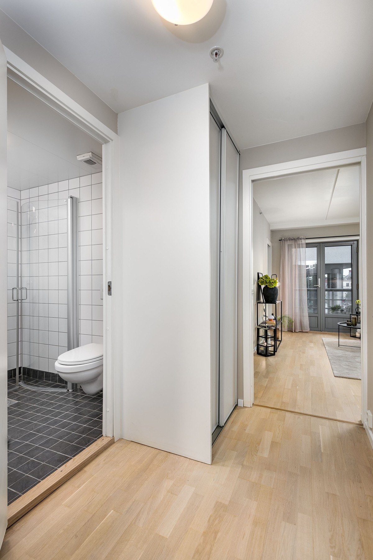 Lys entre med praktisk skyvedørsgarderobe. Galleribilde