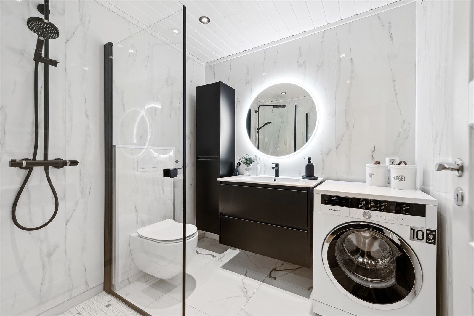 Pent baderom fra 2023 med vegghengt toalett, innfellbare dusjvegger og varmekabler i gulv. Galleribilde