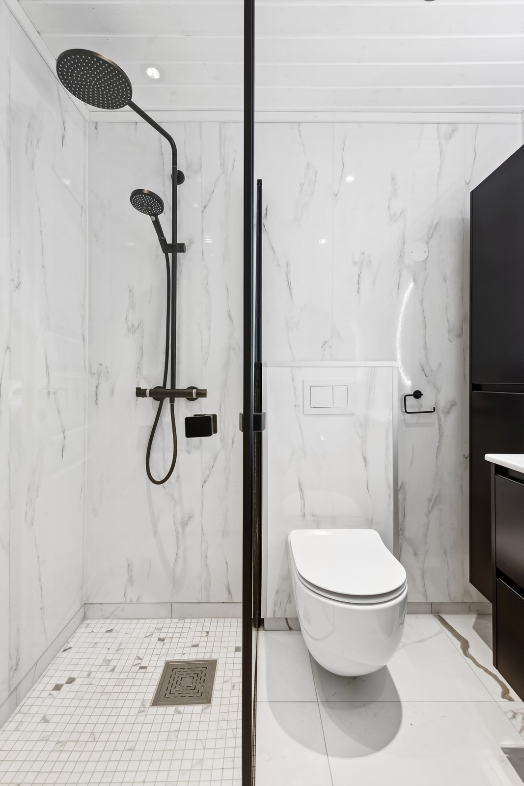 Det er fliser på gulv og baderomsplater på veggene. Galleribilde