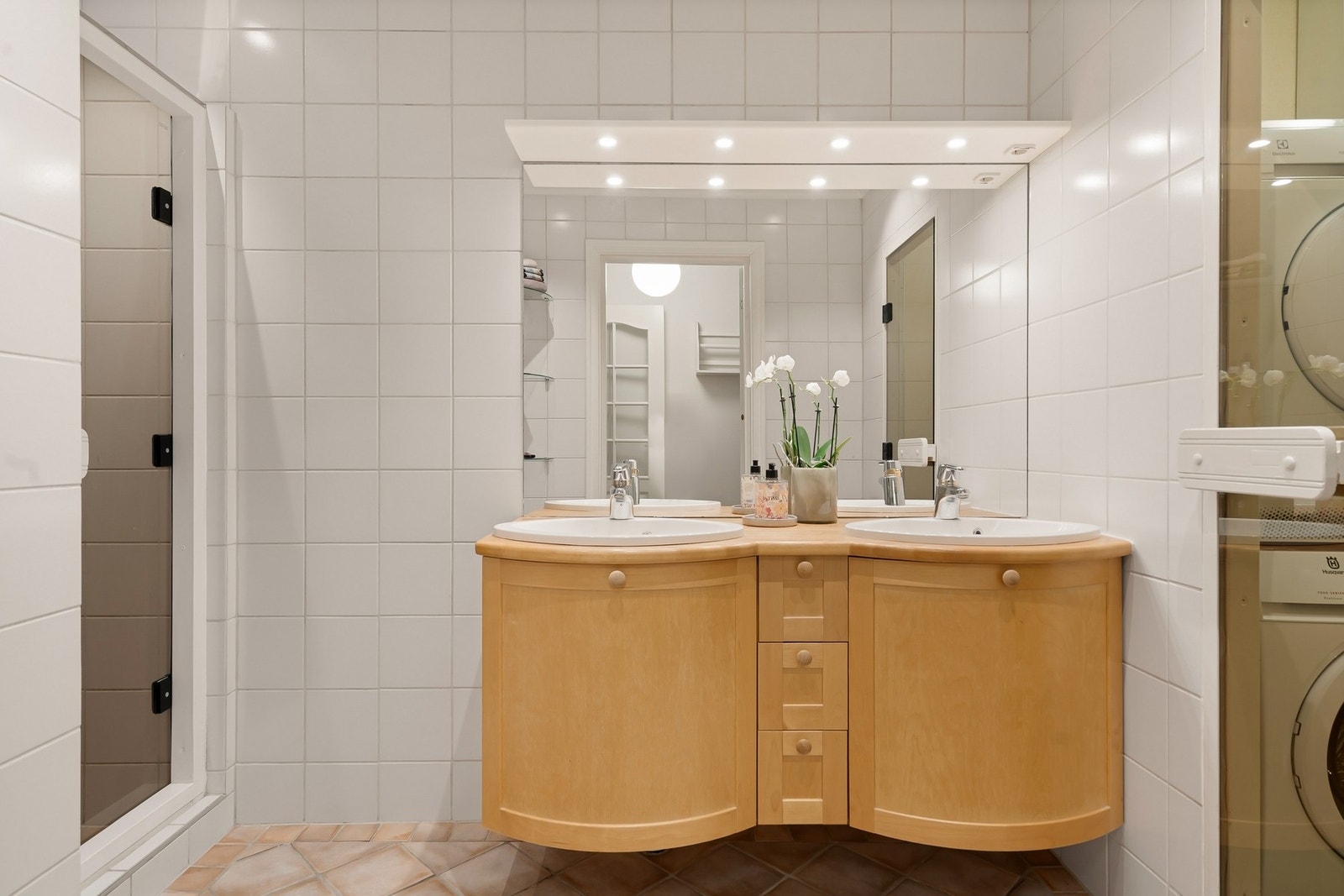 Bad med dusj og servant, med glassdør videre til vaskerom. Galleribilde