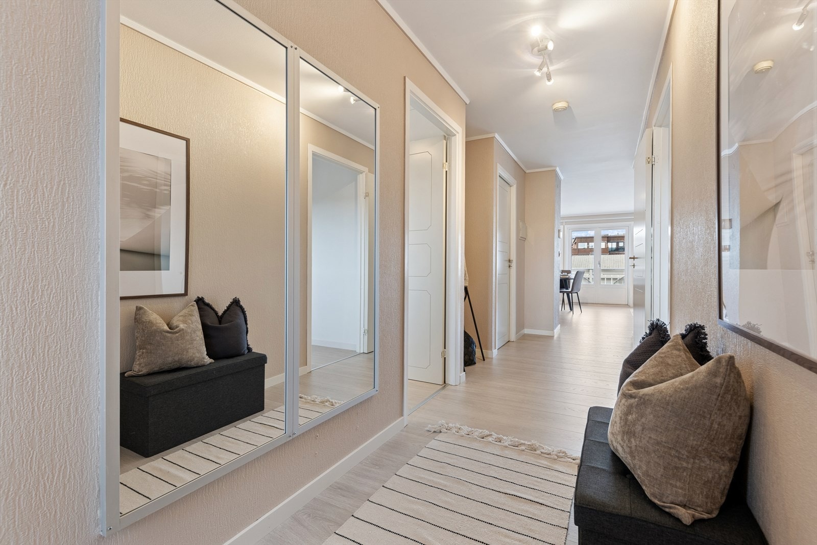 Inngangspartiet er åpent og luftig, med lyse toner og gjennomgående nytt gulv fra 2025. Her er det god plass til å henge fra seg yttertøy. Galleribilde