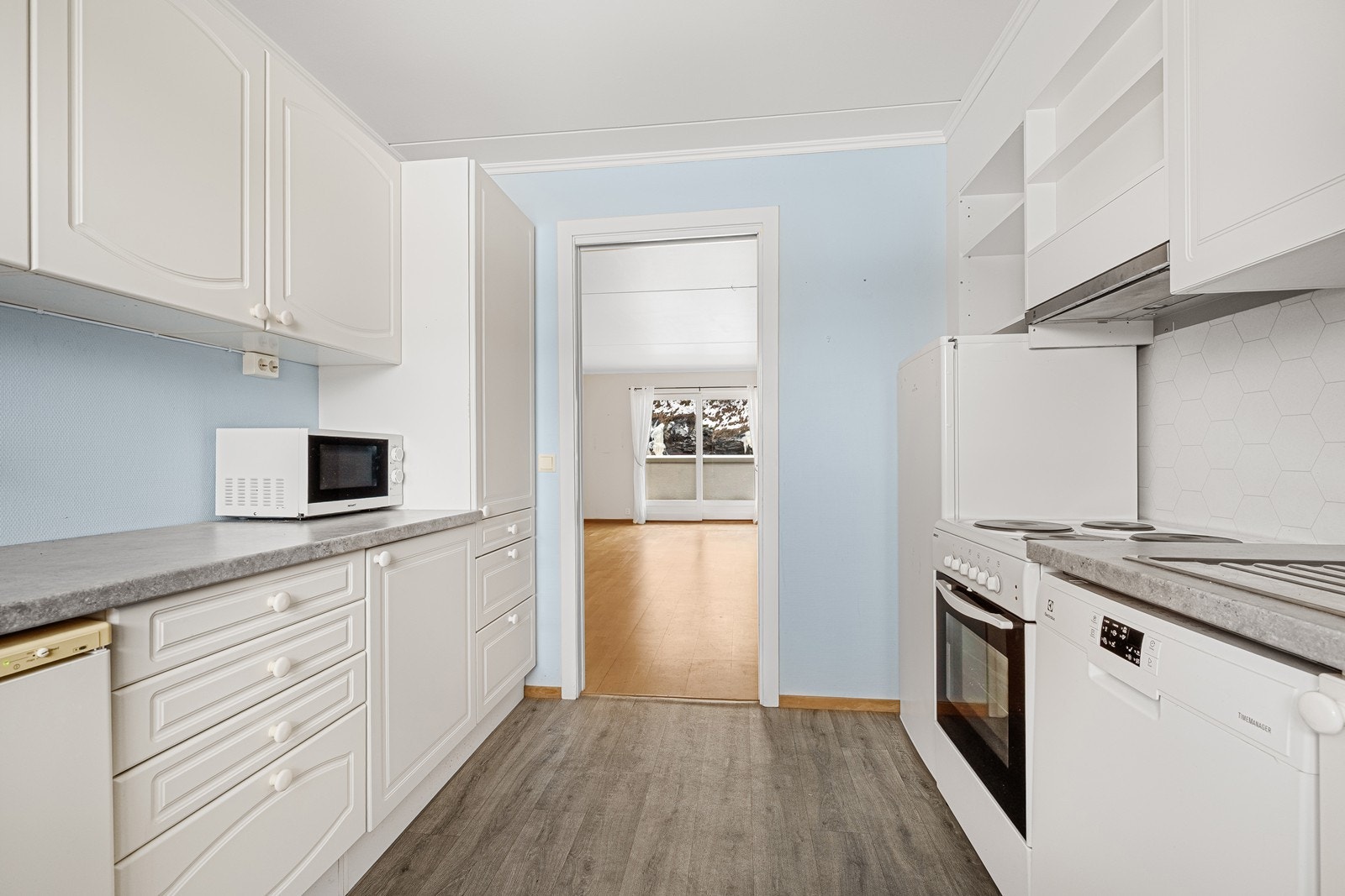 Kjøkken med innredning med hvite profilerte fronter og ny laminat benkeplate. Galleribilde