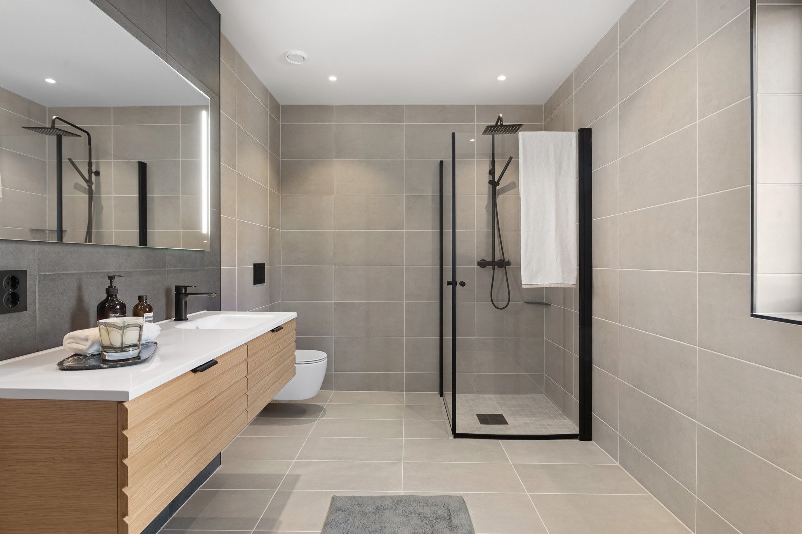 Badet har tidløse fliser og moderne, svarte detaljer. Galleribilde