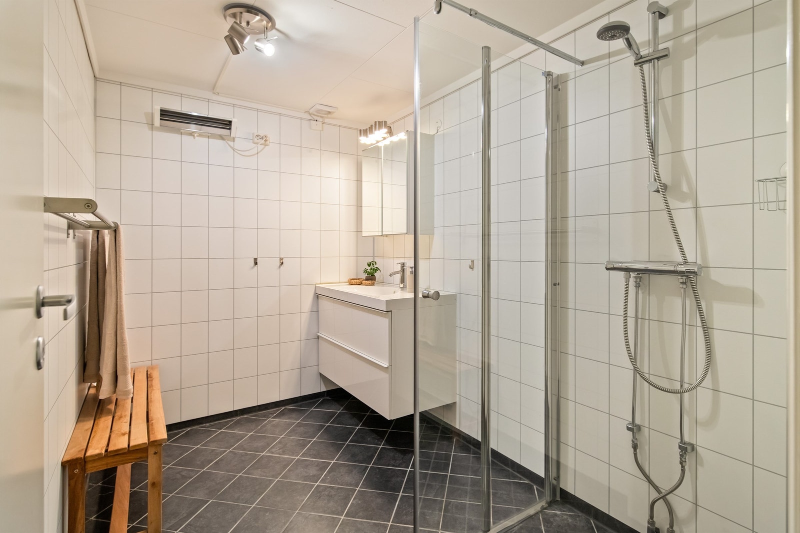 Ett av to bad i kjelleren. Badet ble oppgradert i 2013/2014. Det har fliser på gulvet og veggflater med baderomsplater. Galleribilde