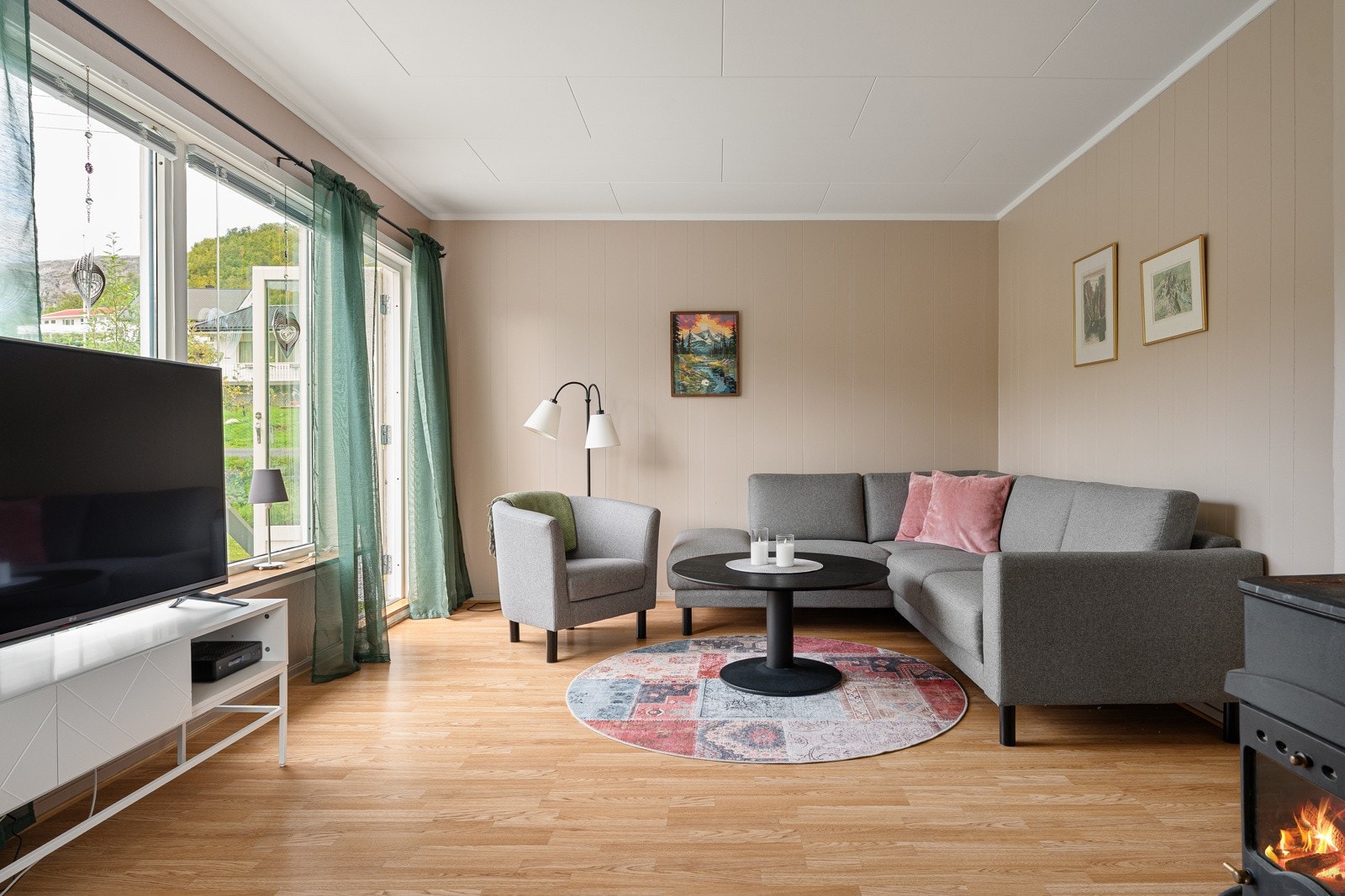 Stue med store vindusflater og utgang til verandaen.