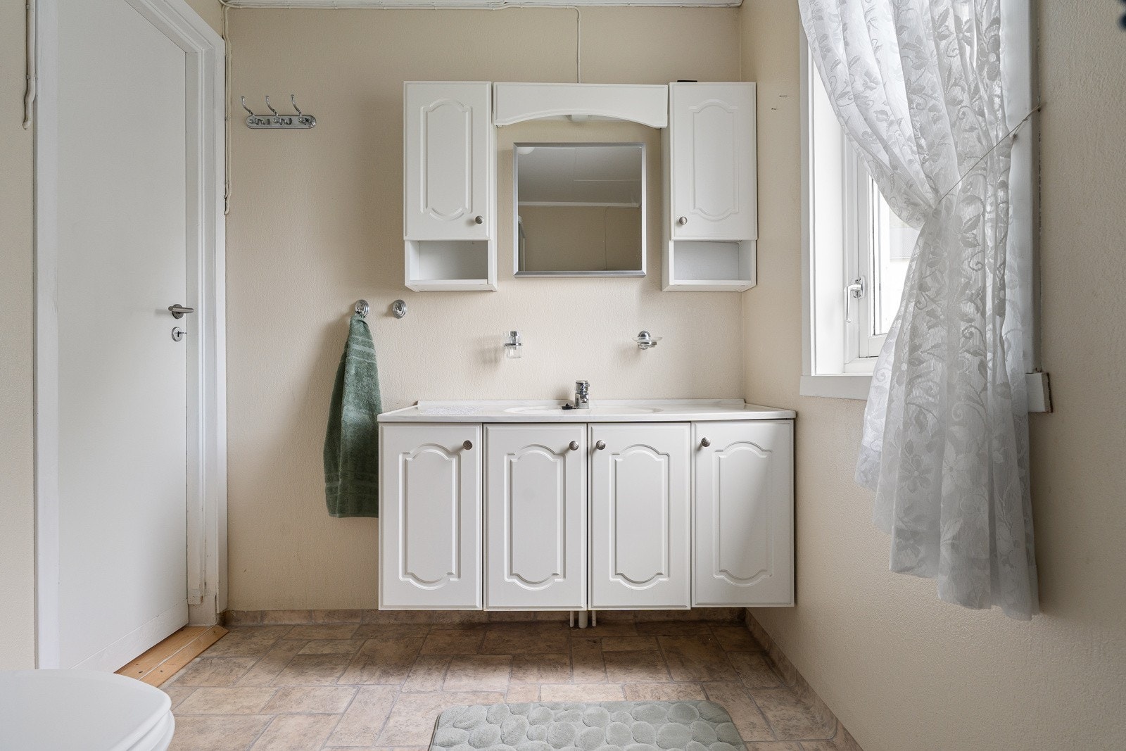 Baderom/wc med stor innredning, servant og speil. Badet fikk nytt gulvbelegg i 2005 og ny dusjkabinett i 2018.