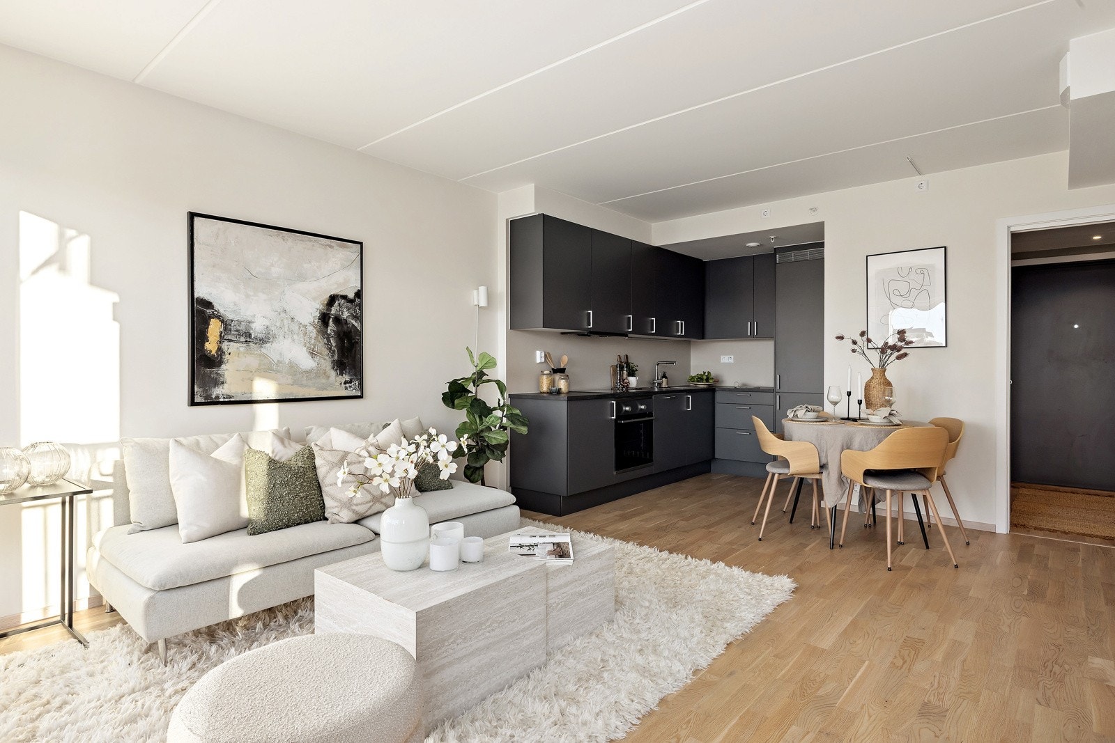 Delt kjøkken-/stue løsning som er moderne og enkelt løst ved at kjøkkenet er pent integrert inn i veggen i hjørnet av rommet. Galleribilde