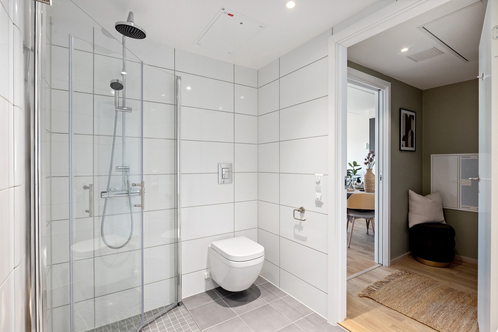 Badet inneholder vegghengt toalett, dusjhjørne med regnfallsdusj, vask med skuffeseksjon samt speilskap med belysning. Det er opplegg for vaskemaskin. Galleribilde