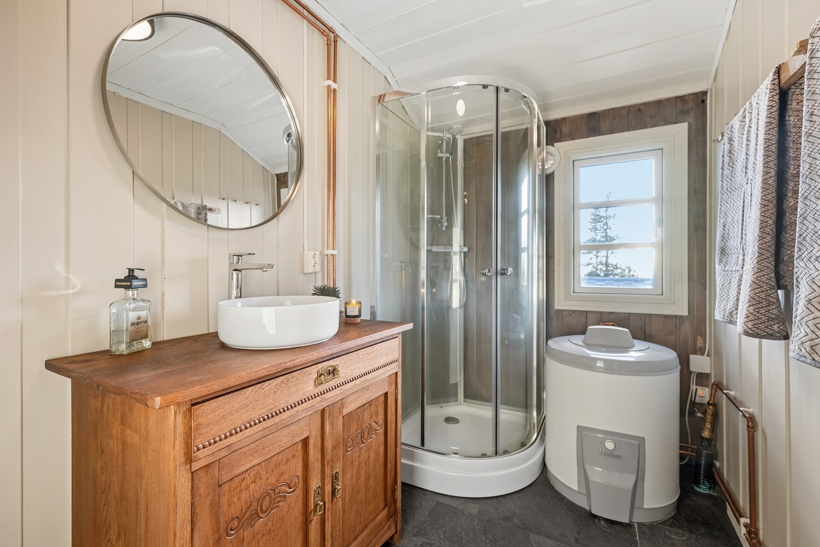 Bad med elektriske varmekabler i gulv samt mekanisk avtrekk. Innredningen består av en servant og et dusjkabinett. Galleribilde