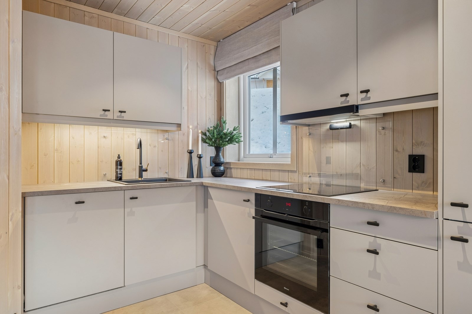 Kjøkkenet er stilrent og moderne, med glatte fronter, laminat benkeplate og integrerte hvitevarer. Galleribilde