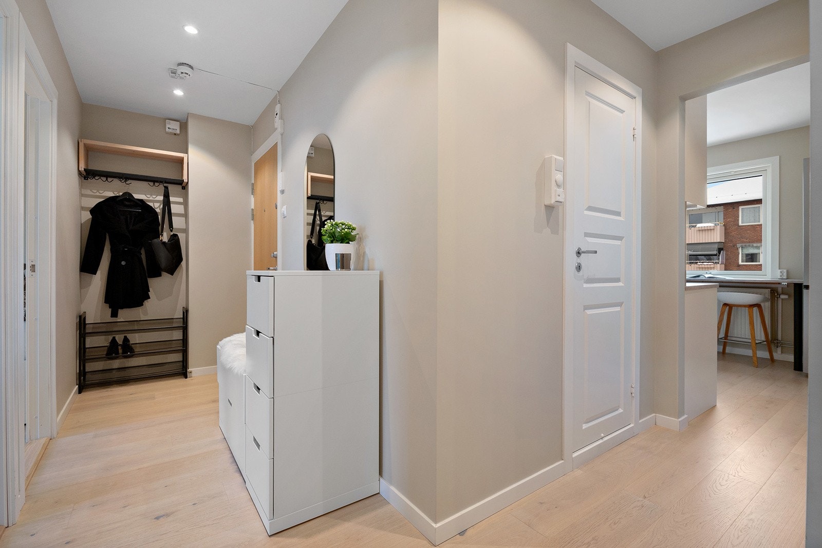 Lys og innbydende entré med plass for å henge fra seg yttertøy og sette fra seg sko. Galleribilde