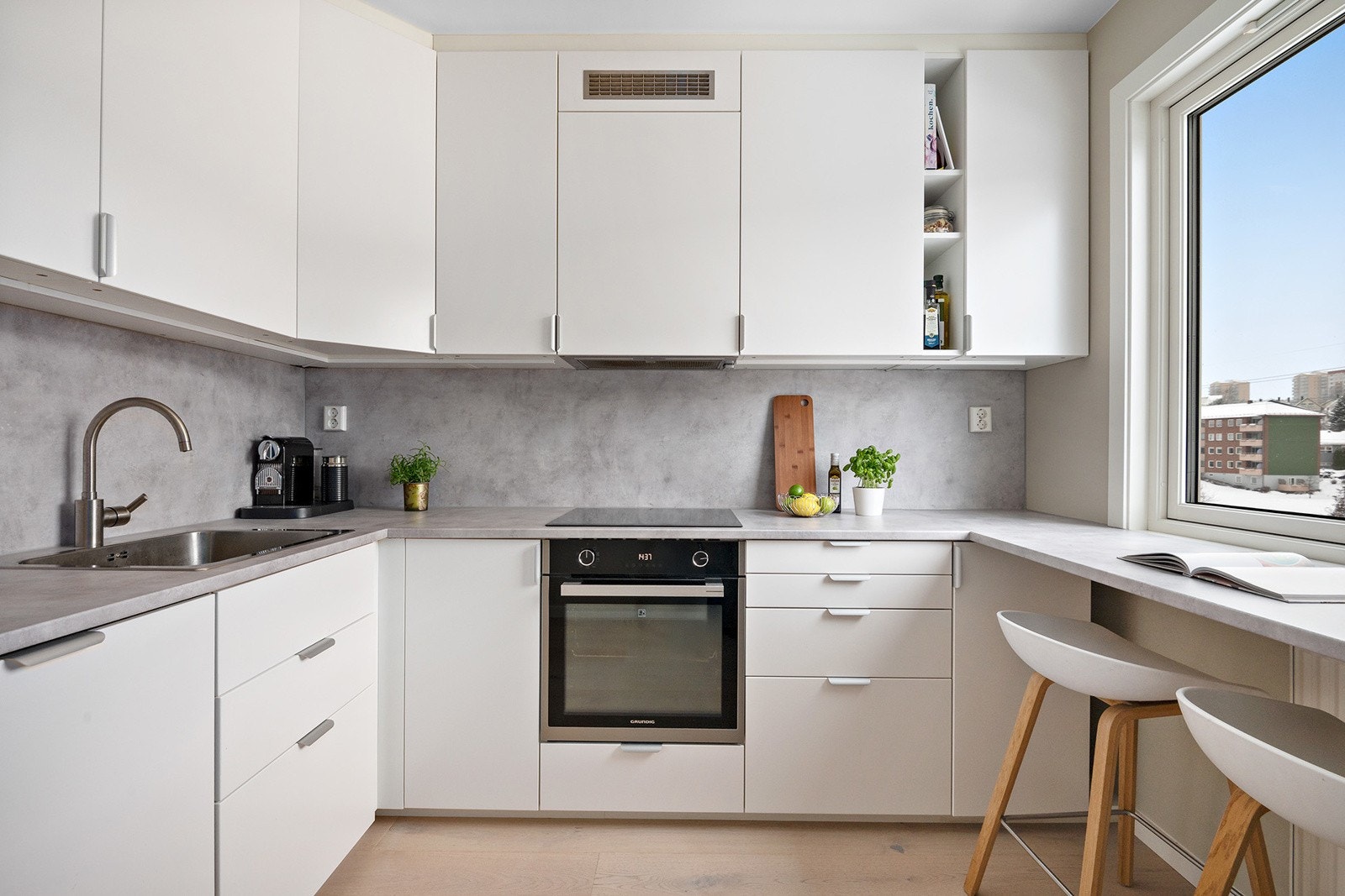 Kjøkkenet ble modernisert i 2023 og har innredning med slette fabrikklakkerte fronter og benkeplate i laminat. Galleribilde