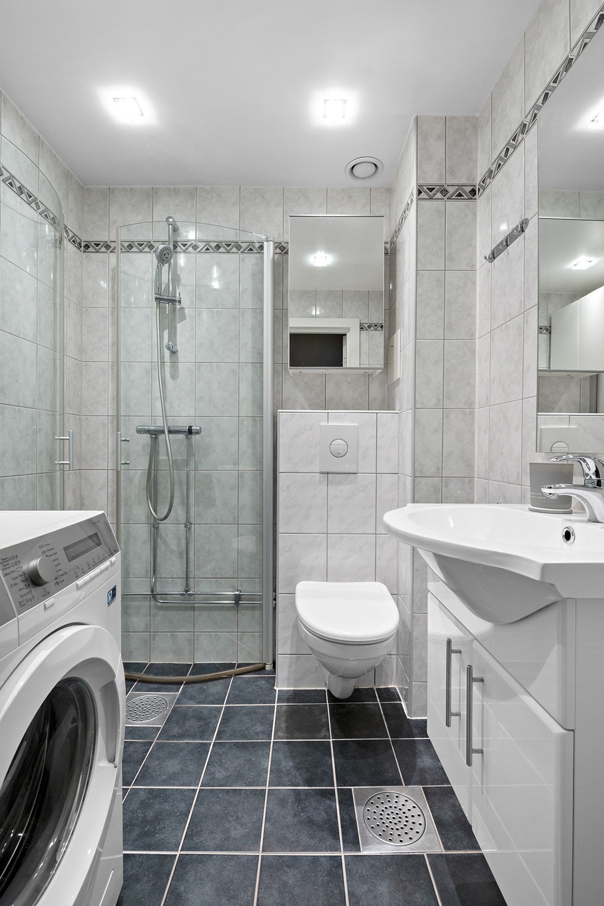 Flislagt bad med varme i gulv og downlight i himling. Veggskap for bedre lagringsplass. Vaskemaskin medfølger Galleribilde