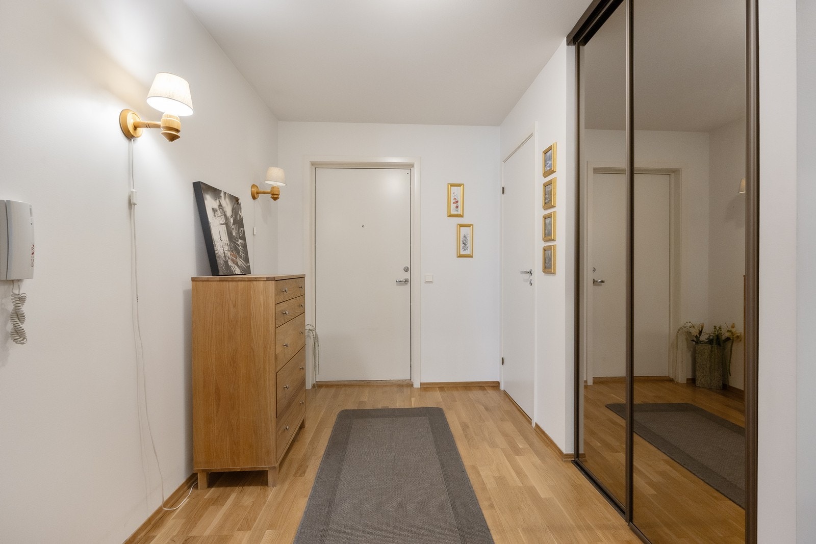 Entréen fremstår lys og romslig med lysmalte vegger mot gyllent gulv. Galleribilde