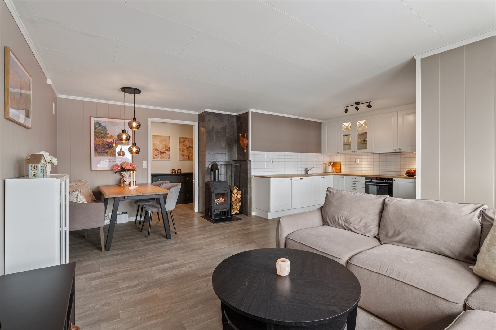 Stuen har lettstelt laminat på gulv og vegger holdt i en klassisk nyanse Galleribilde