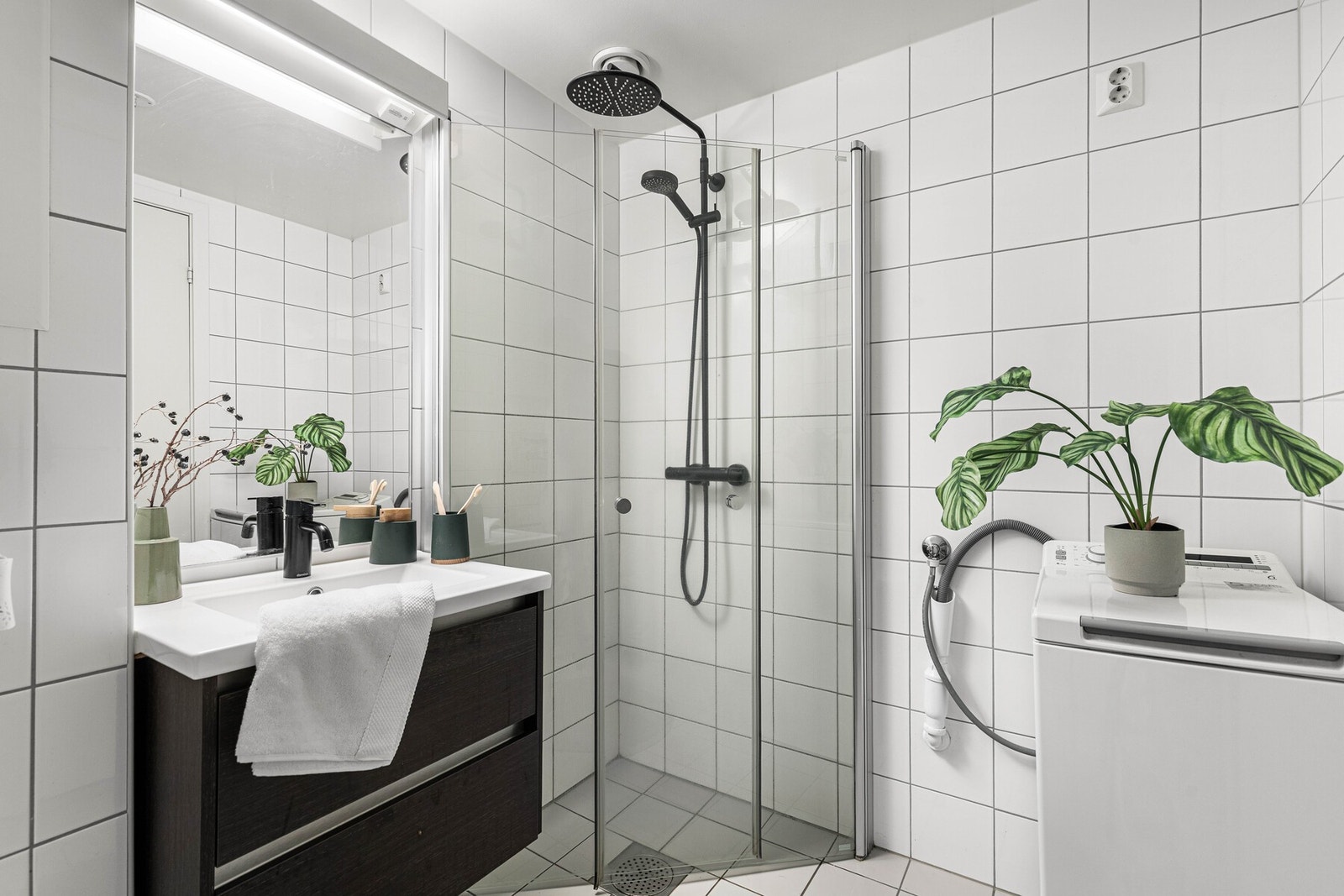 Leiligheten har et funksjonelt og arealeffektivt bad med flislagte overflater og behagelig gulvvarme. Galleribilde