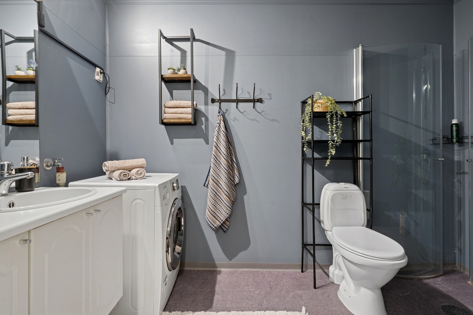 Bad fra byggeår. Gulvflater med gulvbelegg, belagt med foliefliser og malte overflater vegger. Innredning med servant med ett-greps armatur. Overskap, speil samt belysning med stikkontakt på vegg. Galleribilde