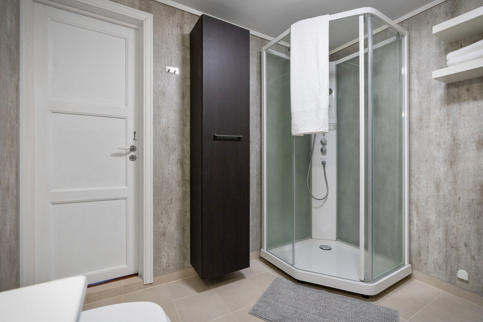 Badet er innredet med dusjkabinett, opplegg til vaskemaskin, nedfelt servant og frittstående toalett. Galleribilde