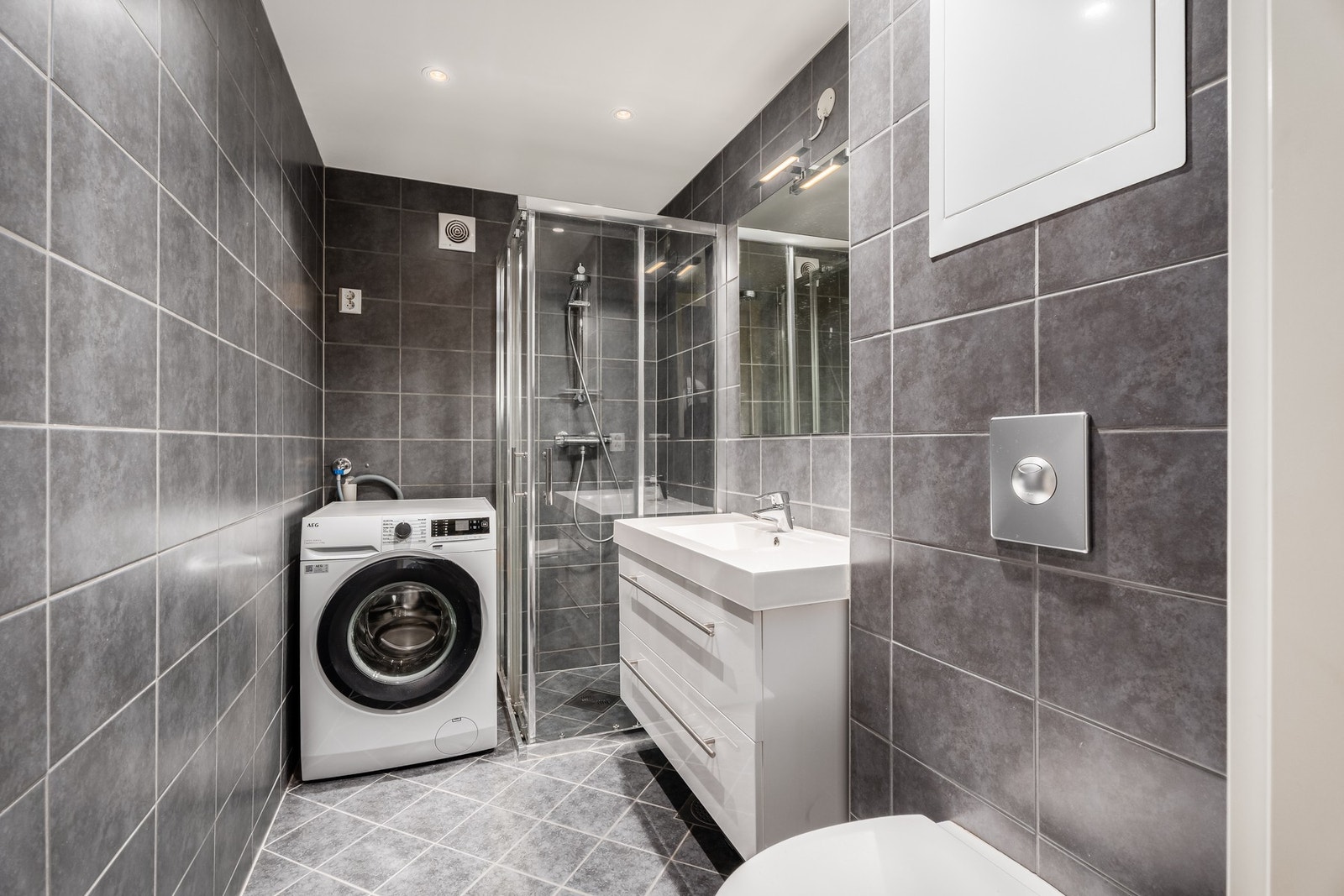 Oppusset bad fra 2014 med varmekabler, spotter i taket og oppsett for vaskemaskin. Galleribilde