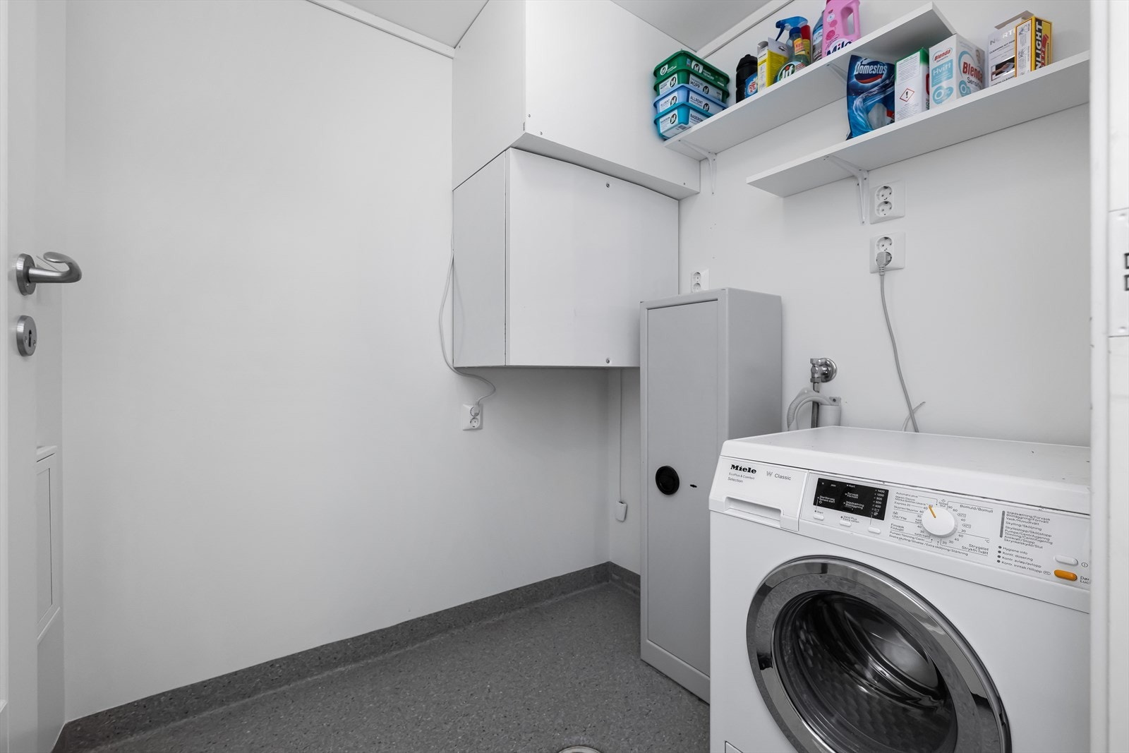 Fra badet er det tilkomst til et praktisk vaskerom. Rommet er godt utnyttet. God plass til både oppbevaring, vaskemaskin og tørketrommel. Galleribilde