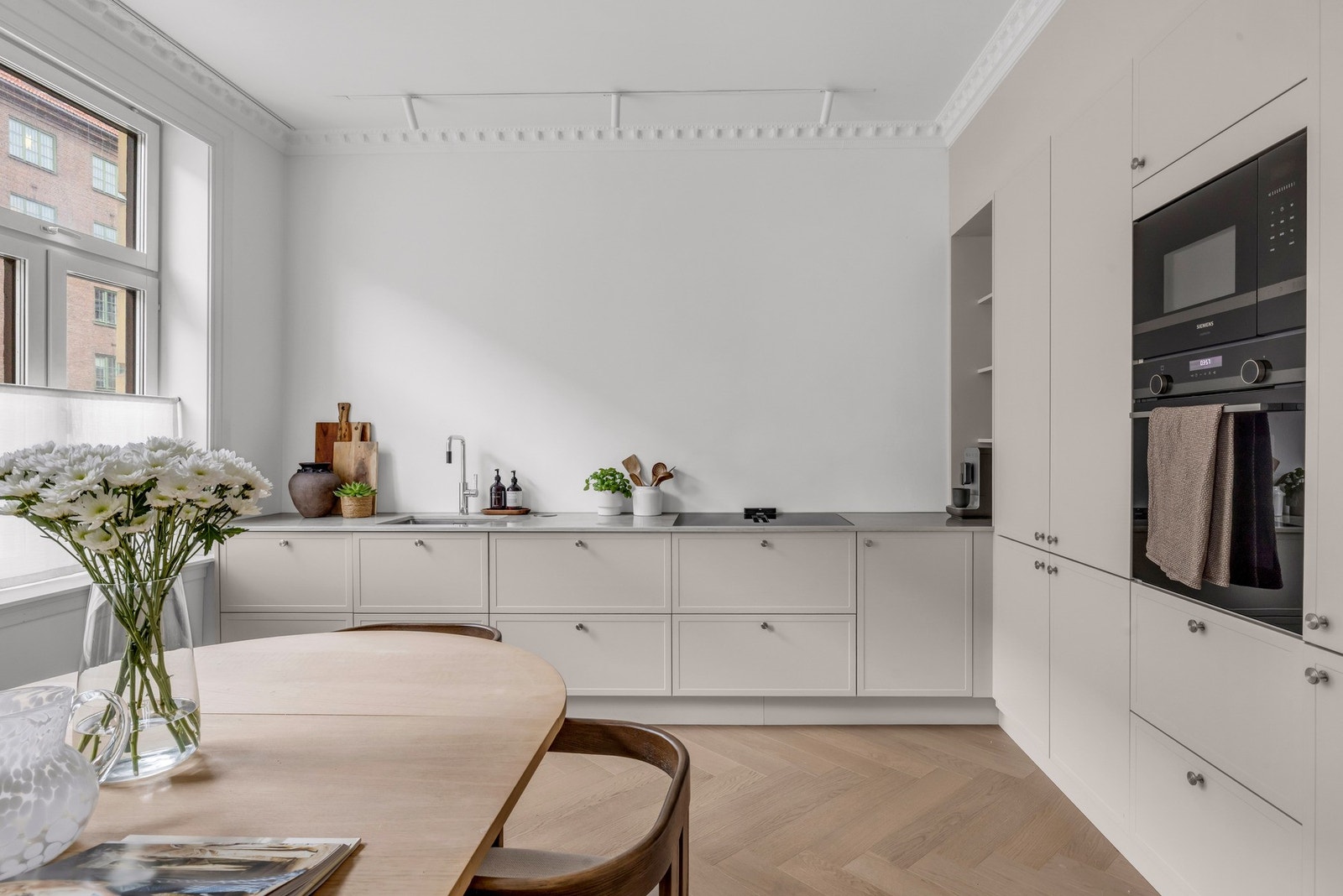 Integrerte hvitevarer som kjøl-/fryseskap, oppvaskmaskin, induksjonstopp og stekeovn. Galleribilde