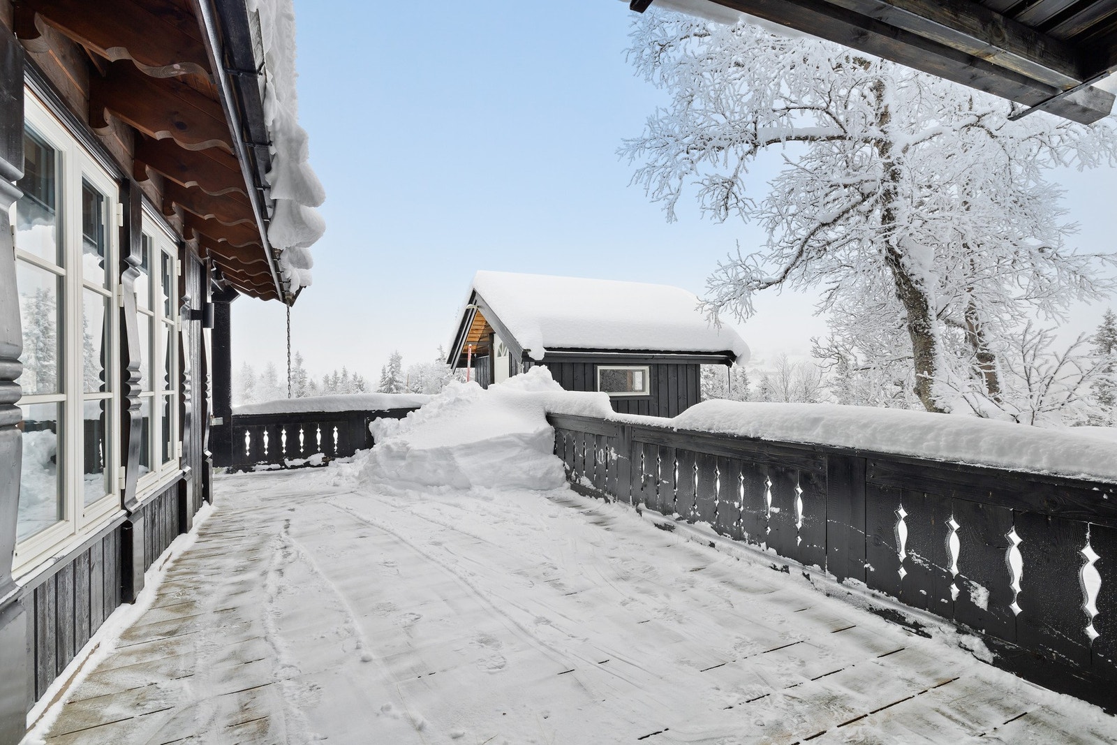 Det er utgang til terrasse som strekker seg langs tre sider av hytta. Galleribilde