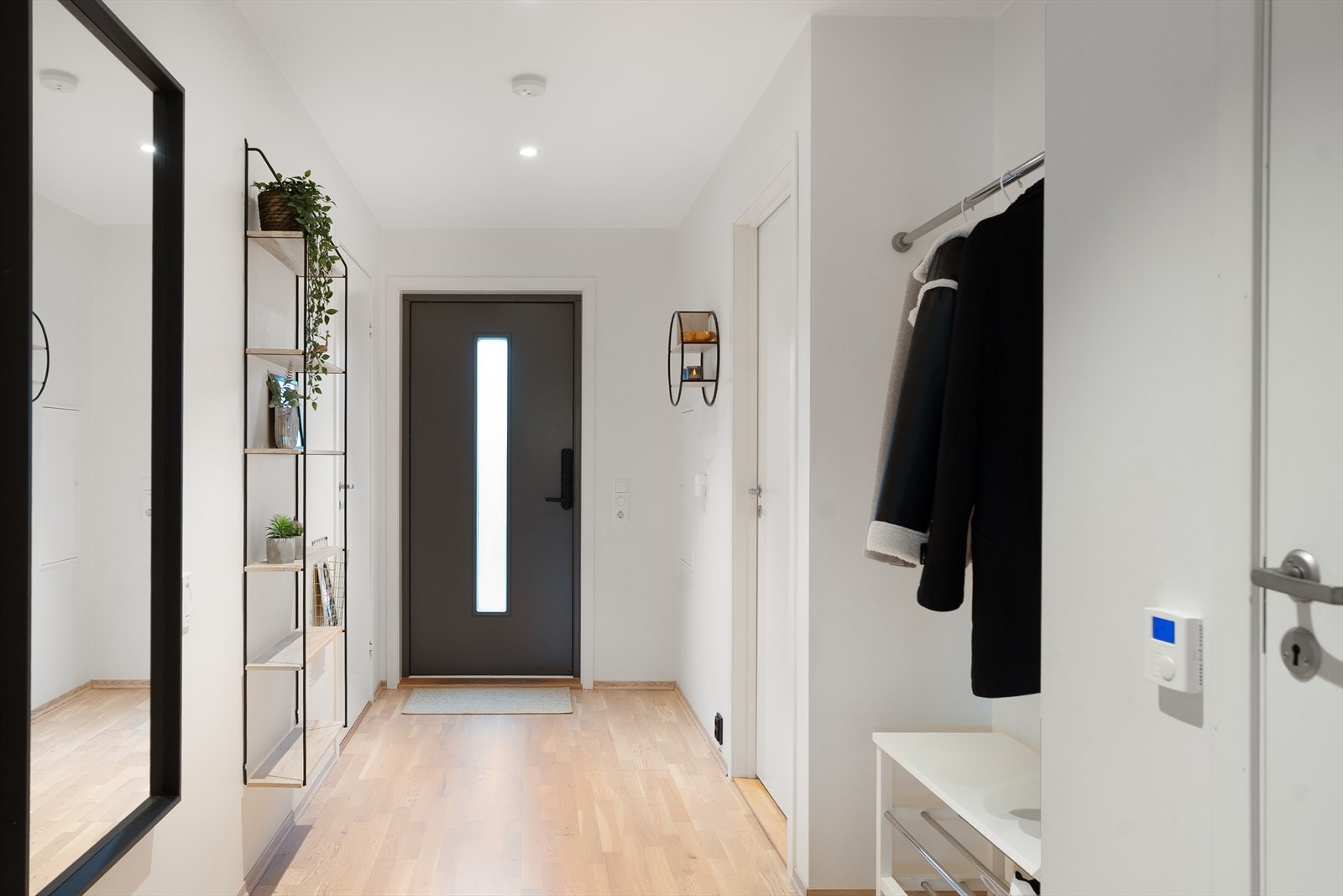 En lys og romslig gang ønsker deg velkommen inn i boligen Galleribilde