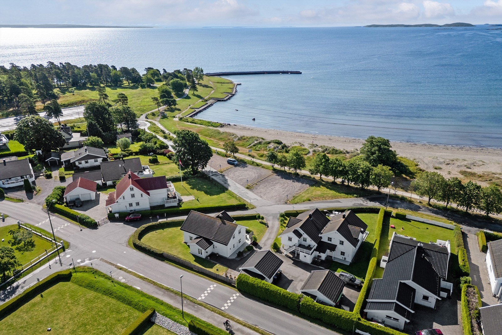 Her bor du solrikt og usjenert på en flott hjørnetomt, med stor hage, vakker beplantning og sydvestvendt terrasse med fjordutsikt. Galleribilde