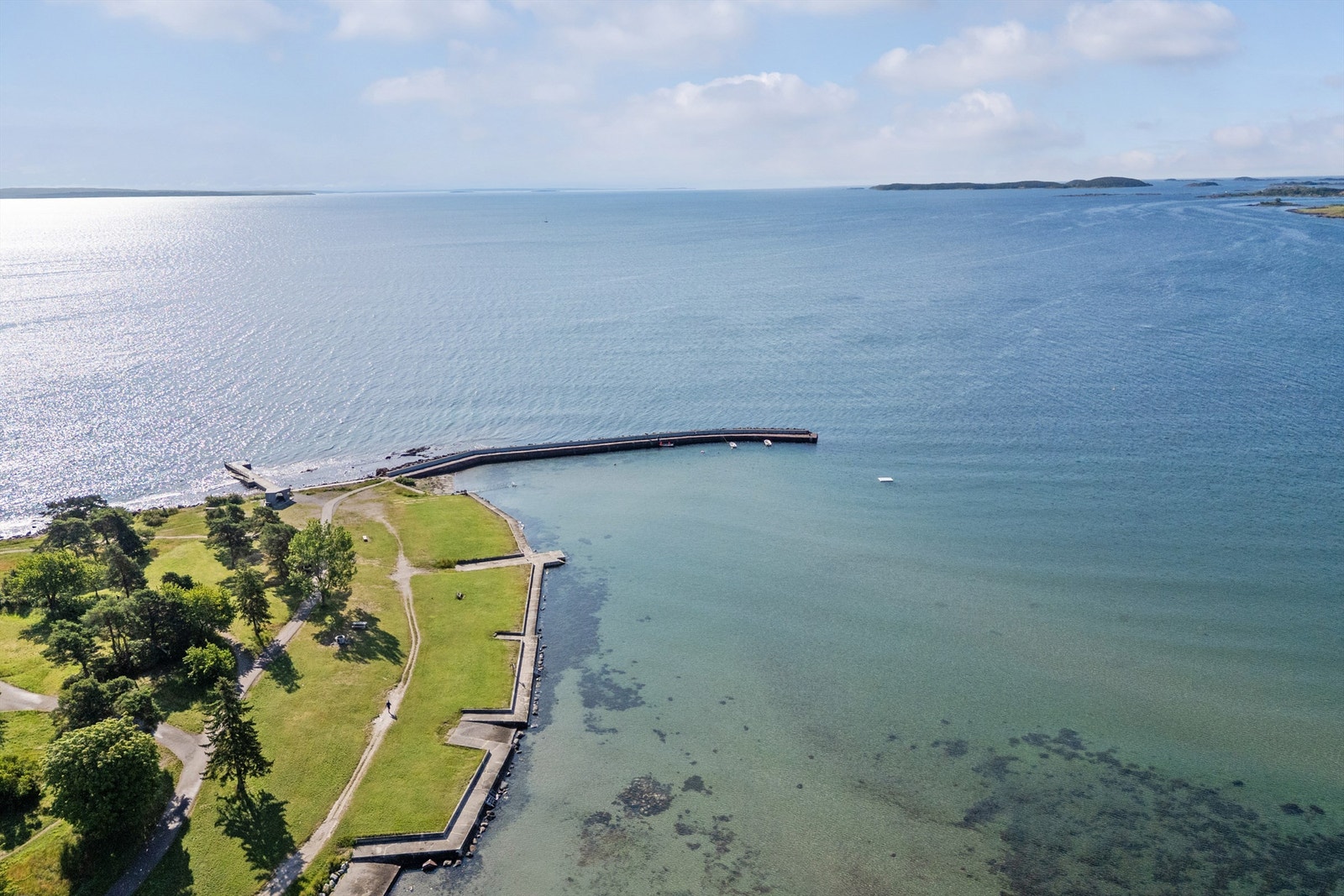 Stranden har steinmolo med badetrapp og stupemuligheter. Galleribilde