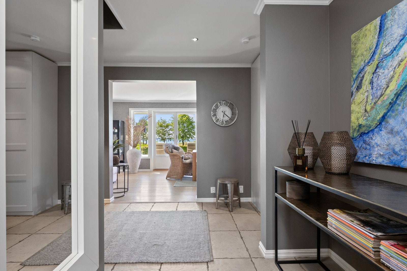 Entreen glir sømløst over i en hall med downlights i taket, innredet med samme type skap og overflater. Galleribilde