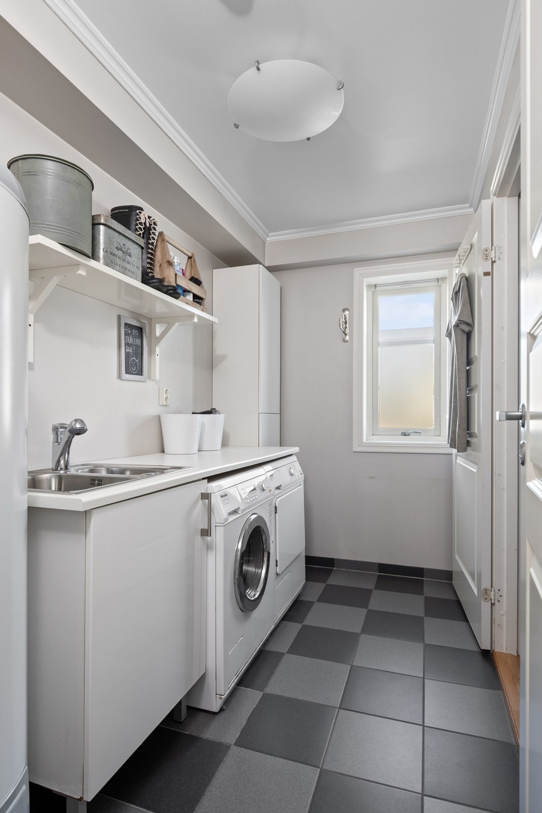 Vaskerommet har flislagt gulv med varme, og i rommet er det etablert et benkeskap med dobbel utslagsvask og tilhørende høyskap. Galleribilde