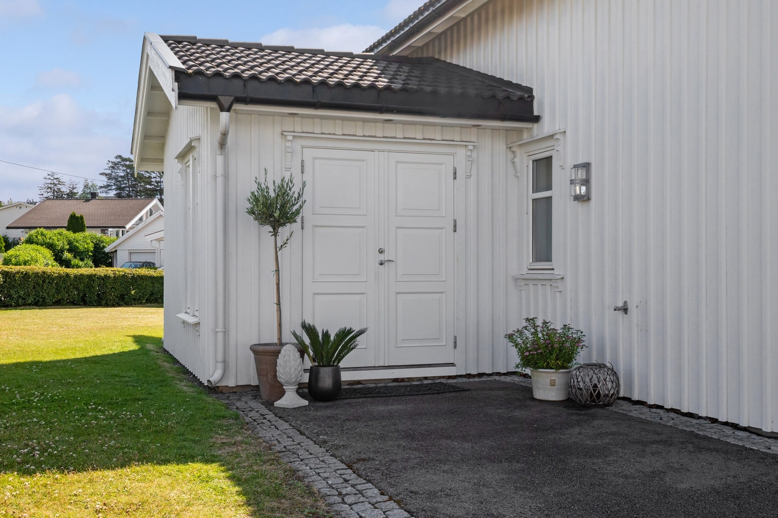 Ytterdøren er tofløyet og overbygd, og ved inngangen har boligen vannkran, downlights og plass til et koselig kafésett. Galleribilde