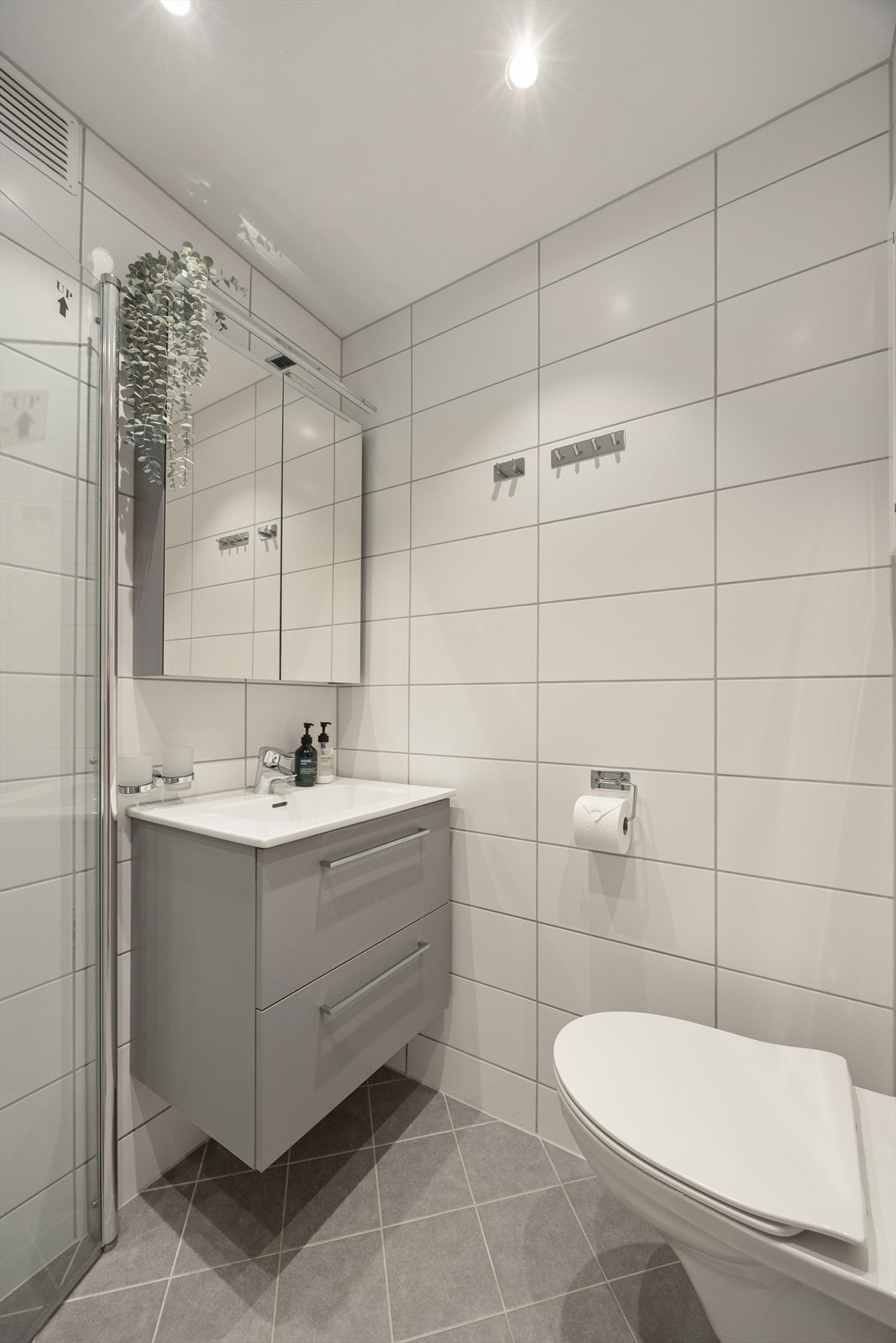 Innredningen består av vegghengt WC, stilrent servantskap og overskap med speildører. Galleribilde