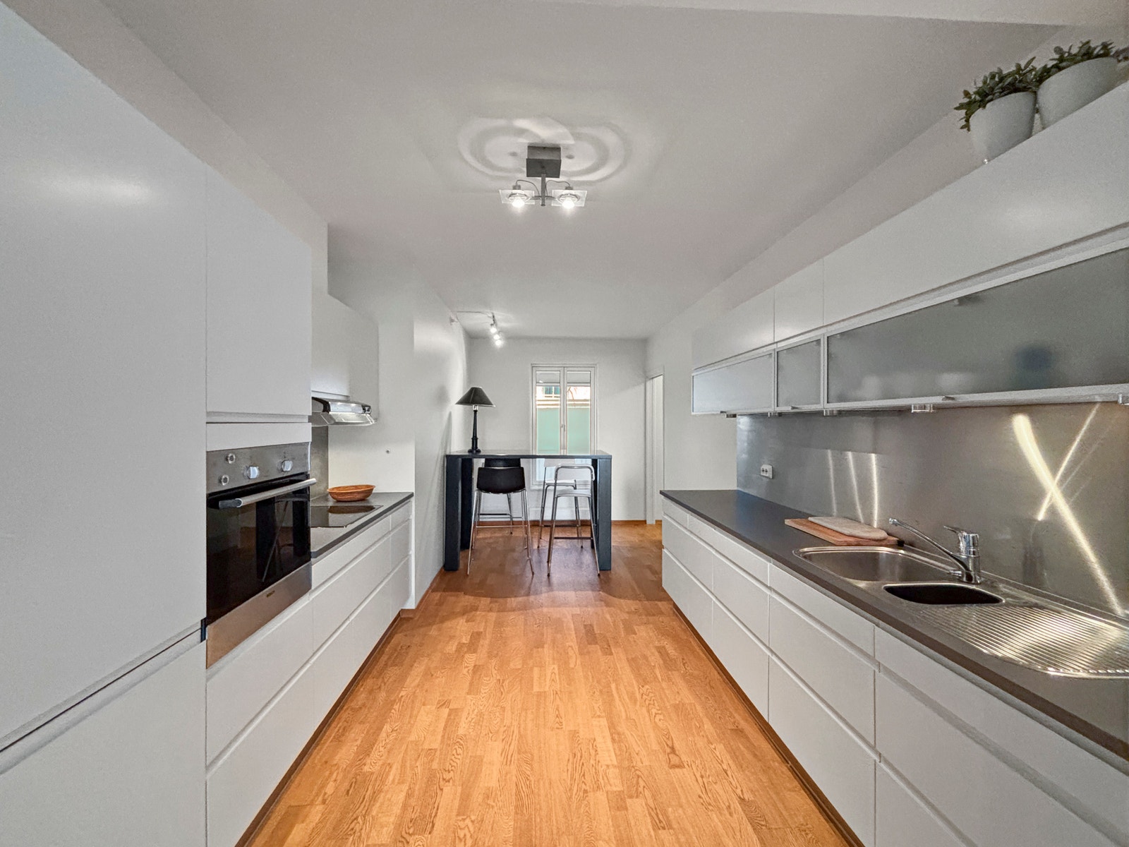 Godt med skap- og benkeplass på kjøkkenet med kjøkkenbord i enden Galleribilde