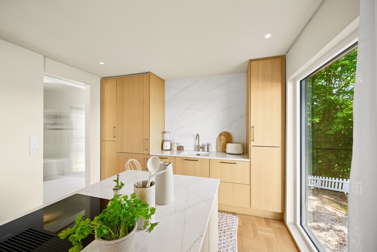 Kjøkkeninnredningen har glatte fronter og en benkeplate i komposittstein med underlimt kum i rustfritt stål. Galleribilde