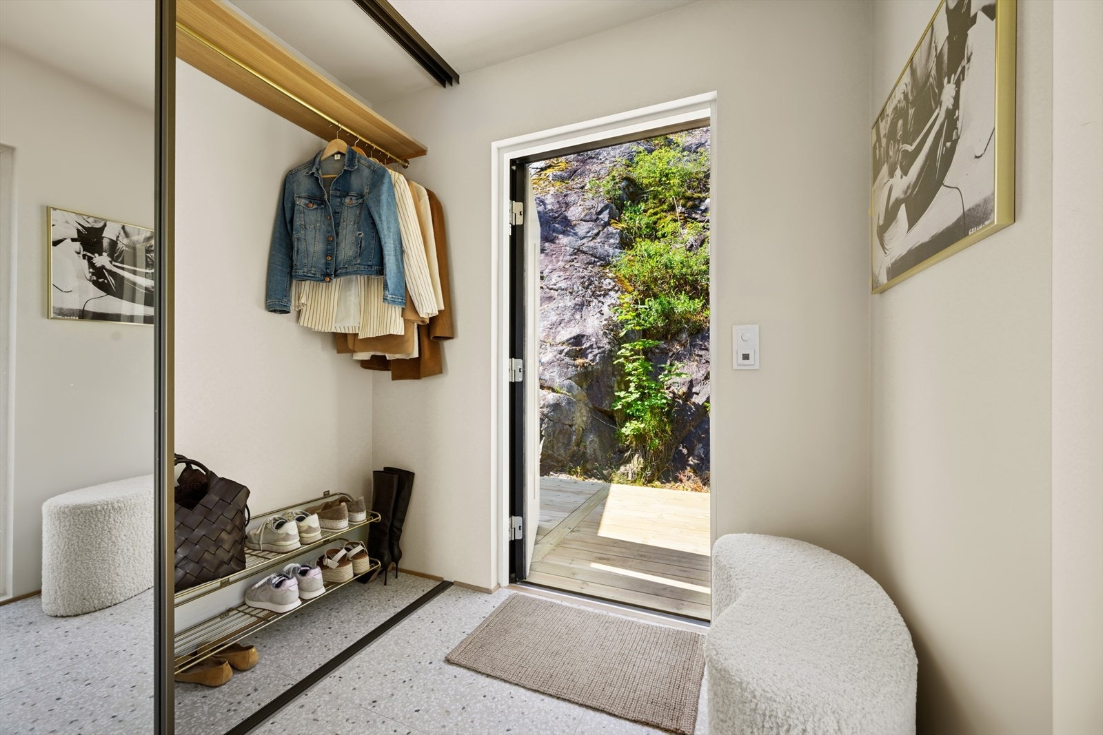 Romslig og innbydende entré hvor yttertøy og sko pent kan oppbevares i en praktisk skyvedørsgarderobe. Galleribilde