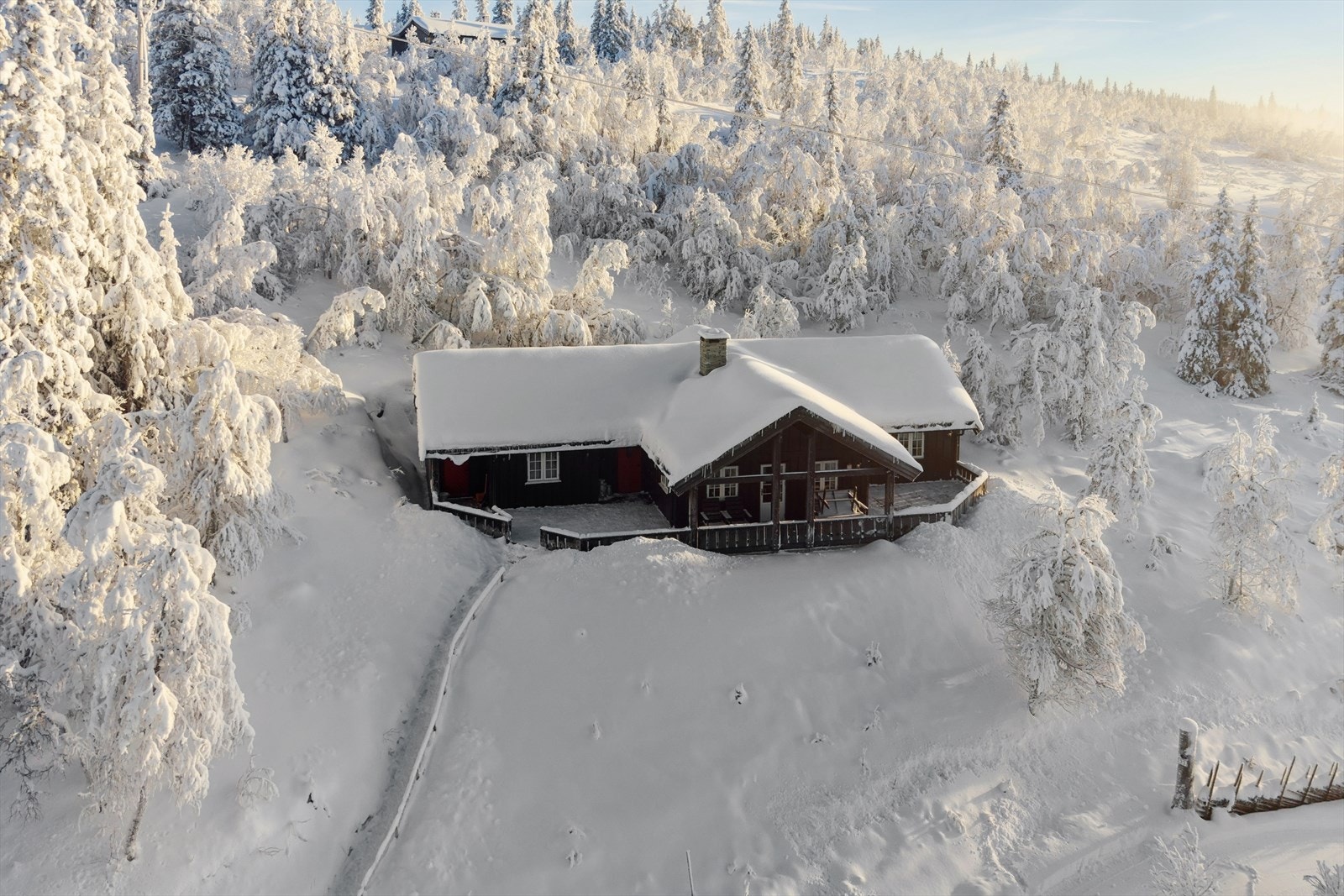 Det er parkering på egen tomt, nedenfor hytta. Det er vinterbrøytet vei på hyttefeltet. Galleribilde