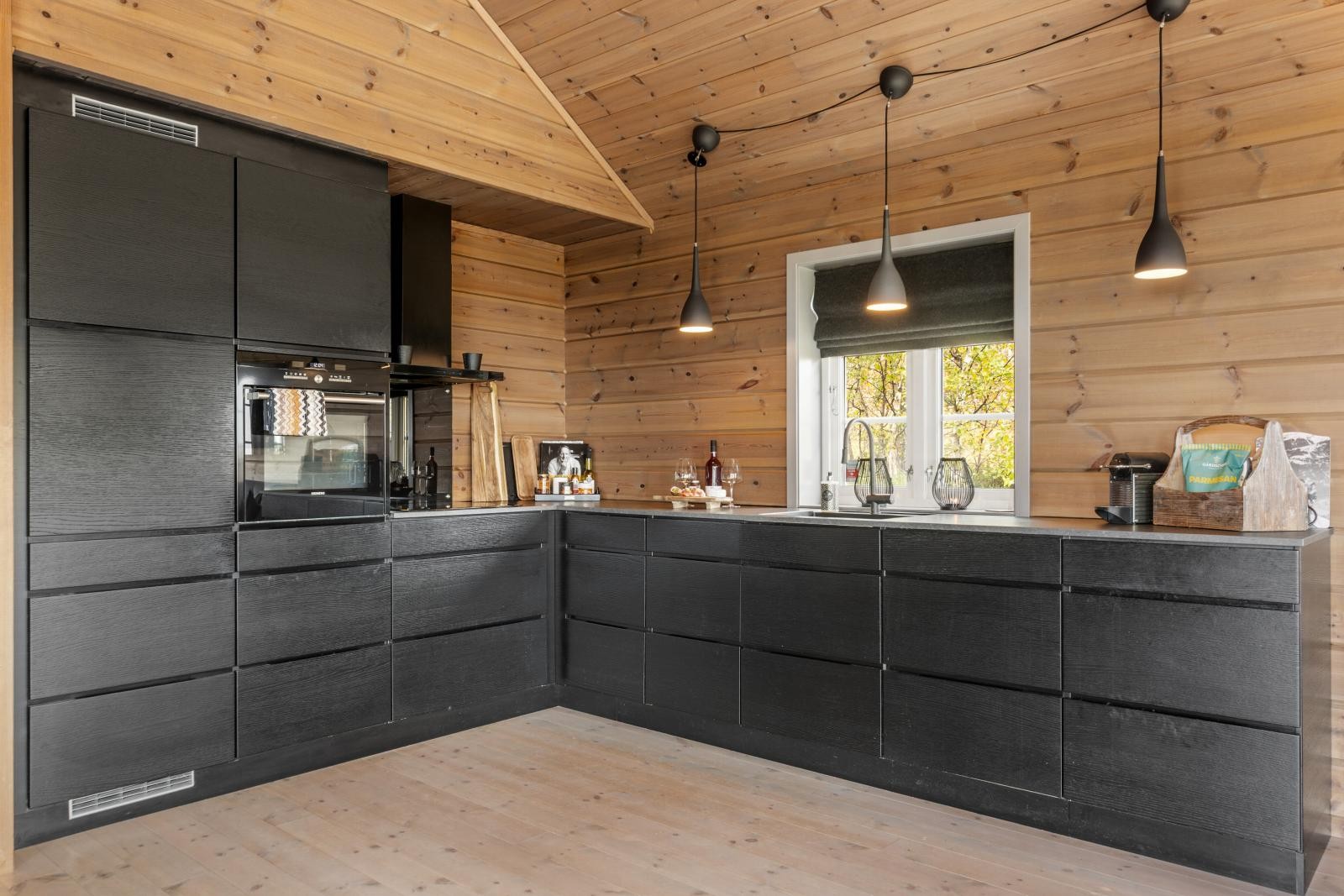 Lekkert kjøkken med rikelig skap- og benkeplass samt integrerte hvitevarer som steketopp, stekeovn, oppvaskmaskin og kombiskap med kjøl- og frysedel Galleribilde