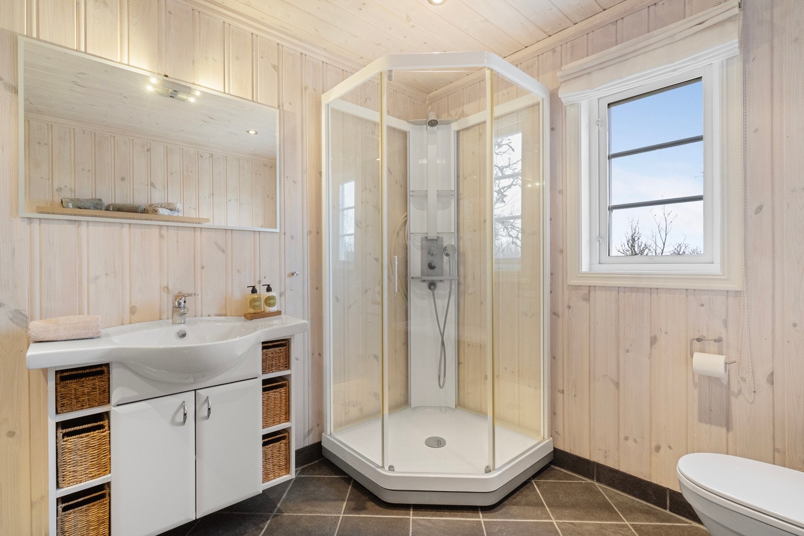 Rommet er innredet med servant med skap, WC, dusjkabinett og opplegg for vaskemaskin. Galleribilde