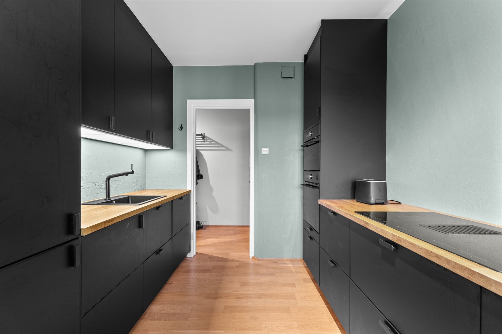 Kjøkkenet inneholder benkeplate av heltrefinert spon, nedfelt oppvaskkum, benkeskapsbelysning med stikkontakt over kjøkkenbenk, integrert kjøleskap med fryser, oppvaskmaskin, mikro/stek og dampovn. Galleribilde