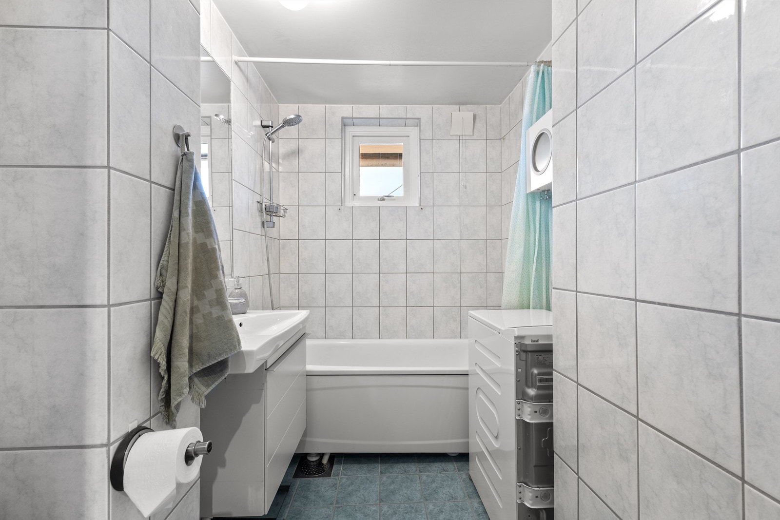 Tidløst, flislagt bad fra 2001 med varmekabler i gulvet og opplegg for vaskemaskin. Galleribilde