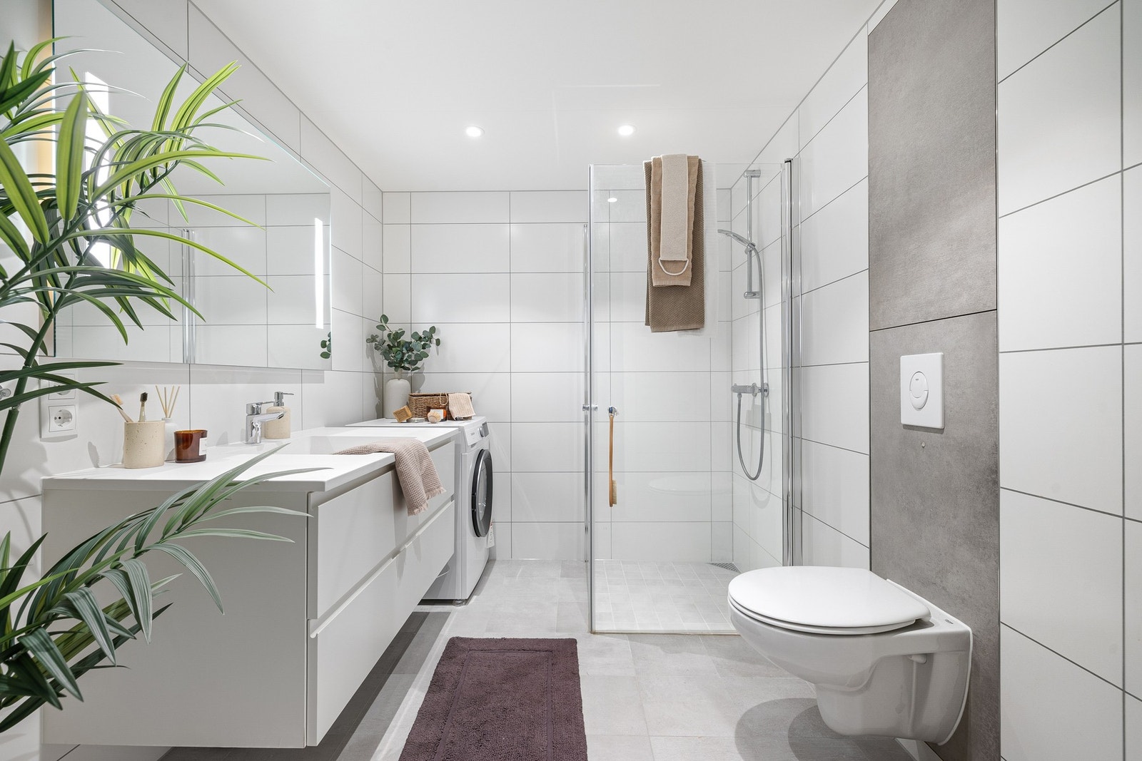 Leilighetens bad er bl.a. utstyrt med innfellbare dusjdører i glass, speil med innfelte lys og grepsfri servantinnredning. Galleribilde