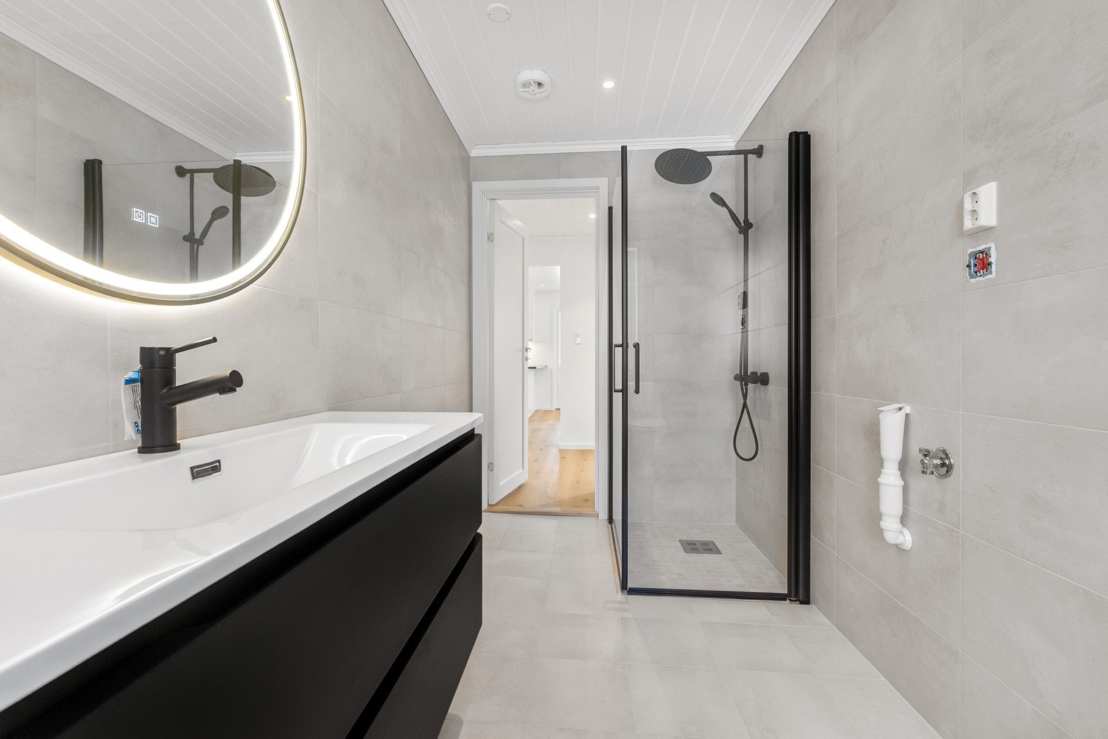 Regnfallsdusj plassert i et hjørne med nedsenket dusjsone og innfellbare dører, og veggmontert hånddusj. Galleribilde