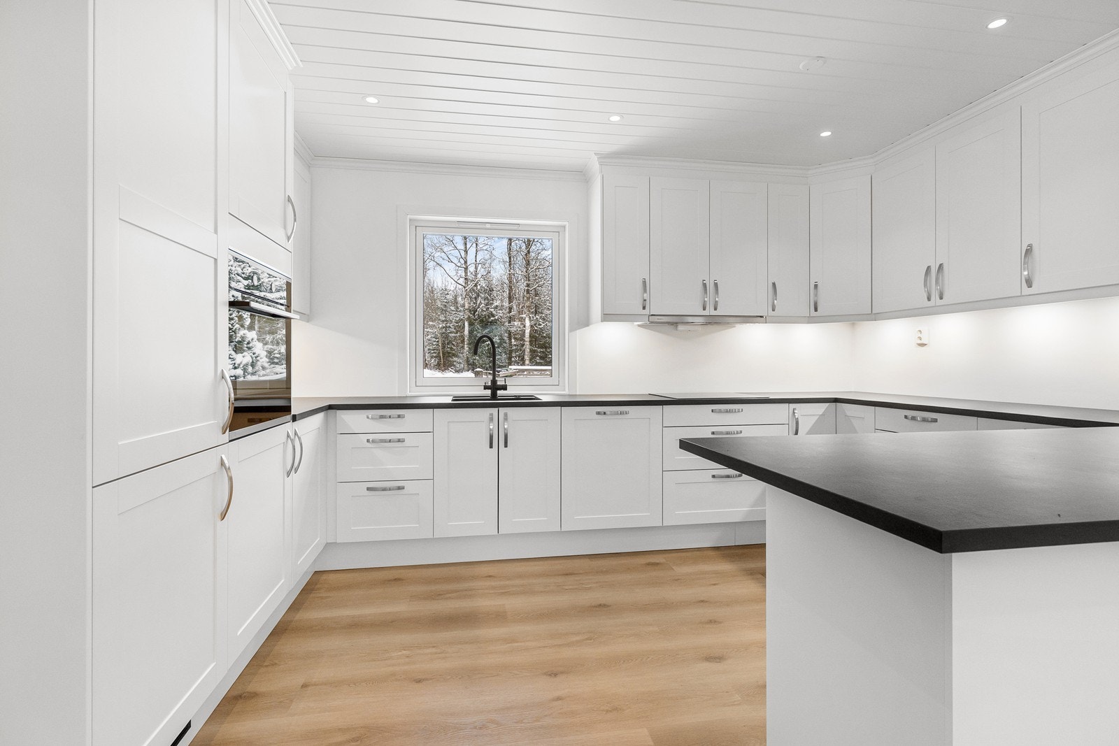 Hvitevarer som kjøleskap med frysedel, stekeovn i høyskap, oppvaskmaskin i benk og en nedfelt induksjon platetopp er integrert og medfølger. Galleribilde