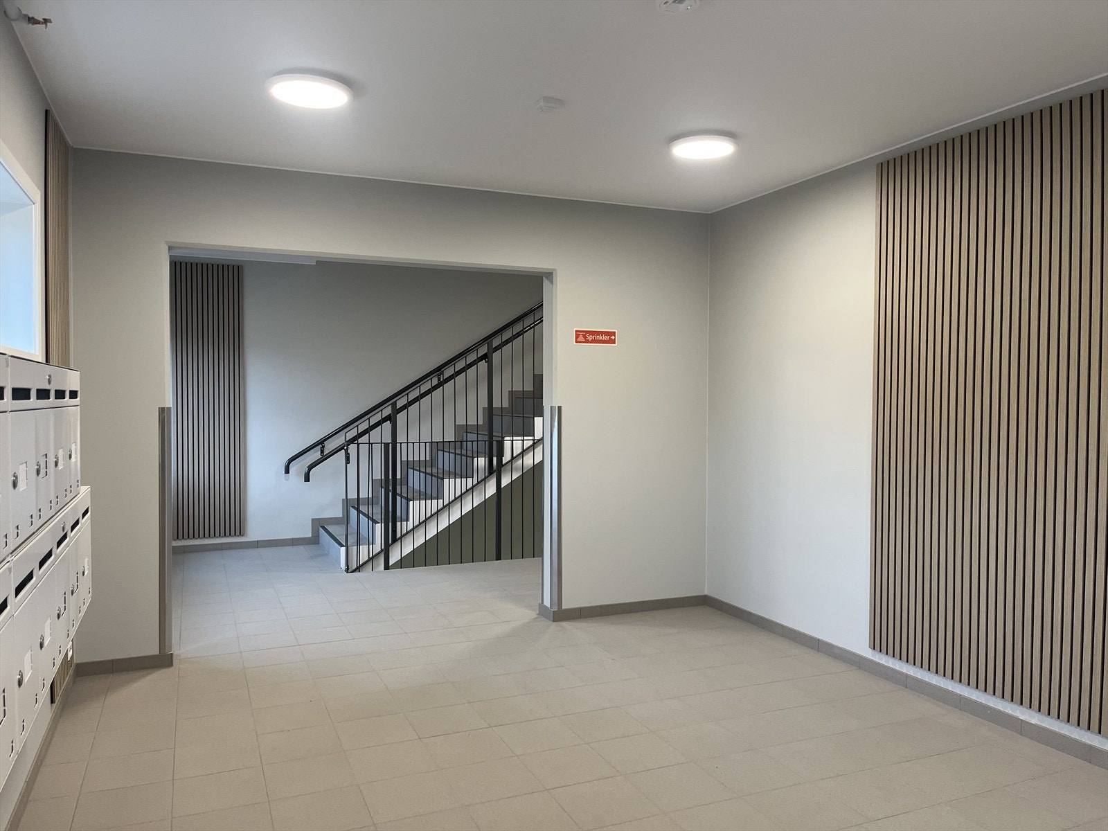 Innbydende fellesarealer med trapperom/heis, flislagt gulv og stilrene detaljer. Fra underetasje er det gang direkte til garasjeanlegget. Galleribilde