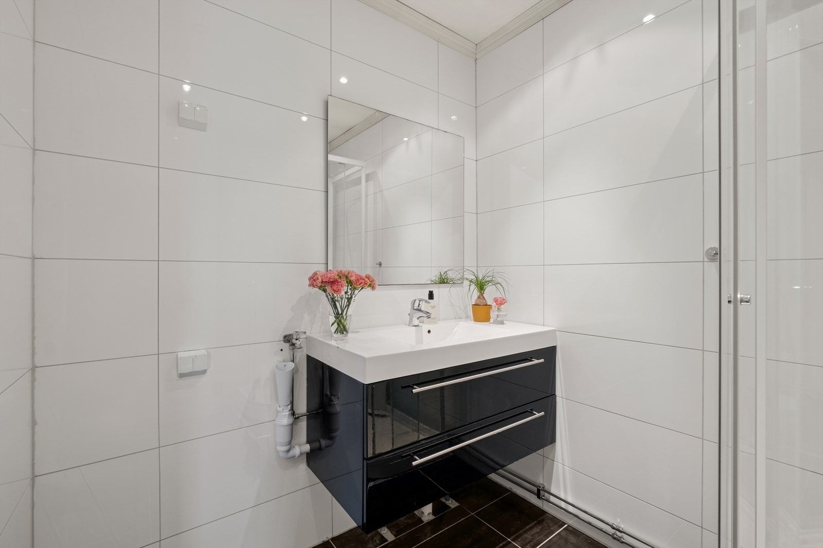 Baderommet er utstyrt med servantinnredning, vegghengt toalett, dusjkabinett og opplegg for vaskemaskin. Galleribilde