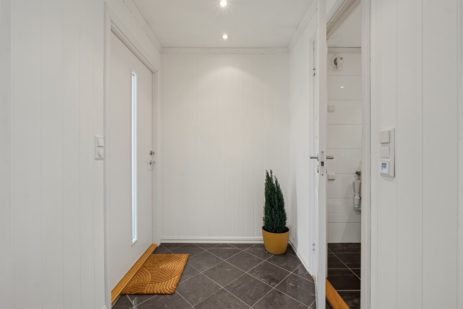 Du ønskes velkommen inn i en lys og hyggelig entré, med praktiske fliser på gulvet. Det er god plass til ytterklær og sko. Galleribilde