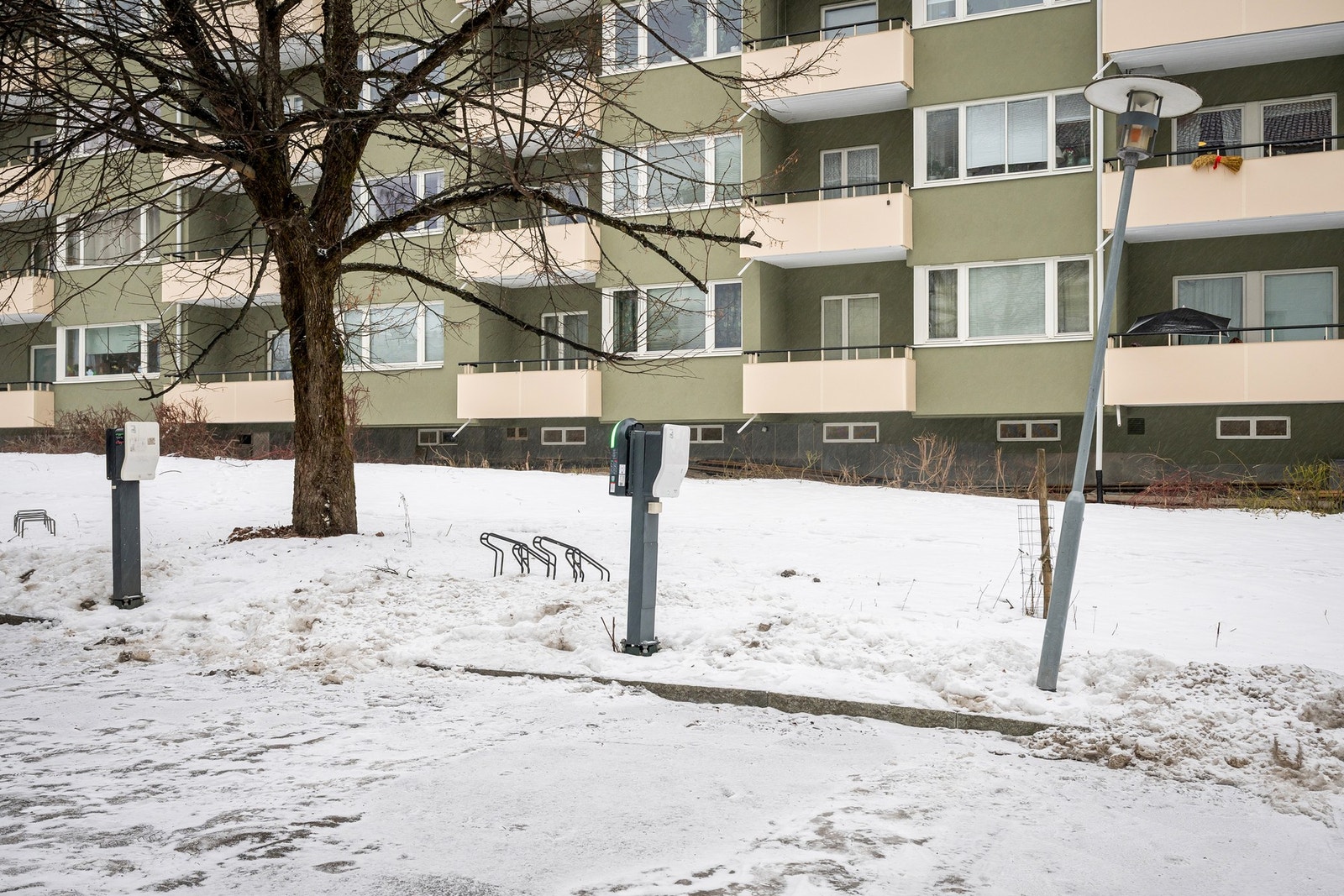 Fast biloppstillingsplass rett utenfor bygget, med elbillader. Galleribilde