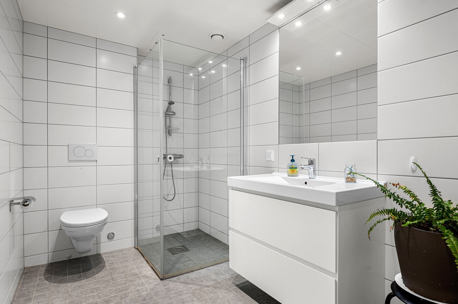 Boligen sitt andre og største baderom har en størrelse på 5,5m² - romslig og stilrent, utstyrt med gulvvarme mekanisk avtrekk, veggmontert wc, innfellbare dusjdører, opplegg for vaskemaskin, servantskap og rørfordelingsskap. Galleribilde