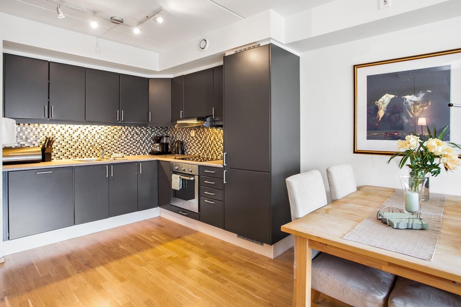 Kjøkken med mørke fronter og integrerte hvitevarer. Galleribilde